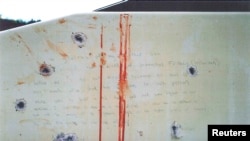 A blood-stained message that prosecutors say Boston Marathon bombing suspect Dzhokhar Tsarnaev wrote on the inside of a boat is seen with bullet holes in an undated evidence picture shown to jurors in Boston, March 10, 2015.