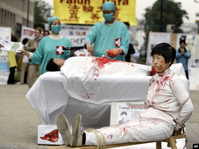 FILE – Falun Gong practitioners simulate organ harvesting in a mock Chinese labor camp in front of the Presidential Office in Taipei, Taiwan, April 23, 2006, in protest against China's suspected abuse and killing of Falun Gong members.