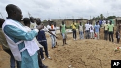 Les habitants de Yopougon observent les recherches d'un charnier présumé le 5 mai 2011.