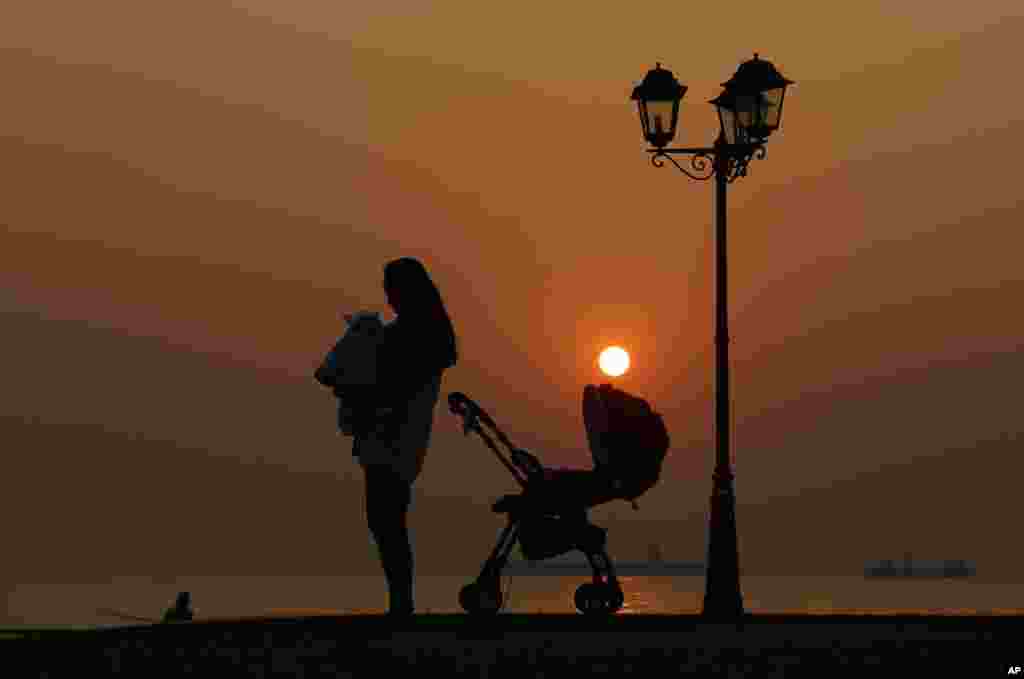 Mother and son are silhouetted against the last sunset of 2013 in Hong Kong.