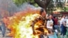 Jamphel Yeshi, a Tibetan exile, runs after setting himself on fire during a protest against the upcoming visit of Chinese President Hu Jintao to India in New Delhi, March 26, 2012.