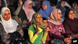 A girl in the women's section of the audience claps as she watches the filming of a new Islamic version of "American Idol," launched to promote and drum up talent for the Arab world's first Islamic pop music video in a bid to capitalize on a generation of