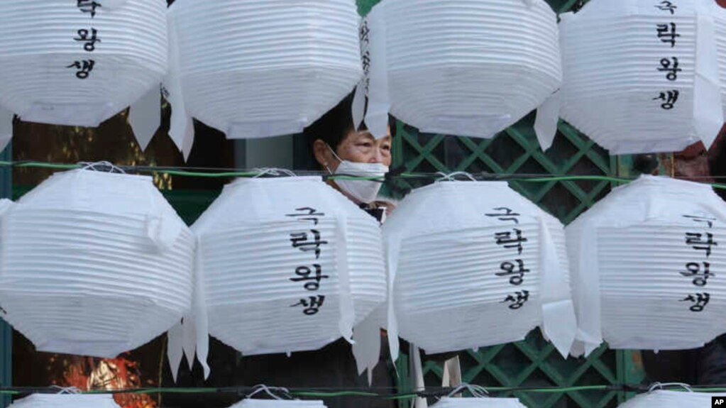 新冠肺炎疫情持续在韩国蔓延，在首尔的一座寺庙内有妇人戴上了口罩
