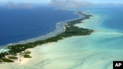 This March 30, 2004, file photo, shows Tarawa atoll, Kiribati. Rising sea levels caused by global warming threaten the very existence of their tiny Pacific nation of Kiribati, one of the lowest-lying countries on Earth. (AP Photo/Richard Vogel, File)