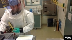 资料照片：病毒学专家斯宾塞·斯通尼尔在位于马里兰德特里克堡的陆军传染病医学研究院的生物安全四级实验室中处理埃博拉样本。(2014 年12月11日)