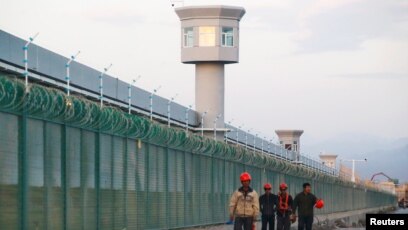Tư liệu: Công nhân đi ngang qua một trại cải tạo có hàng rào vây quanh, mà chính quyền gọi là 'trung tâm huấn nghiệp' tại Dabancheng ở vùng Tân Cương, TQ, ngày 4/9/2018. REUTERS/Thomas Peter