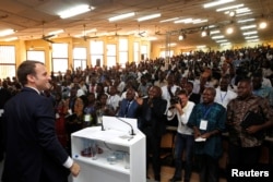 French President Emmanuel Macron speaks with students after he delivered a speech at the Ouagadougou University, in Ouagadougou, Burkina Faso, Nov. 28, 2017.