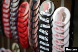 FILE - A vendor sells #MeToo buttons during a protest march for survivors of sexual assault and their supporters in the Hollywood section of Los Angeles, California, Nov. 12, 2017.