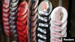 FILE - A vendor sells #MeToo badges at a protest march for survivors of sexual assault and their supporters in the Hollywood section of Los Angeles, Nov. 12, 2017.