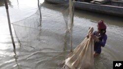 A Cambodian fisherman holds a bag loaded with fish from the Mekong River on the outskirts of Phnom Penh, Cambodia (FILE).