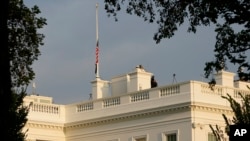 Workers walk on the roof of the White House in Washington, Thursday, Aug. 26, 2021, after lowering the flag for the U.S. service members and other victims killed in the terrorist attack in Kabul, Afghanistan. (AP Photo/Susan Walsh)