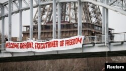 一名活动人士吊挂在一座桥上，抗议伊朗总统鲁哈尼访问巴黎（2016年1月28日 资料图）。