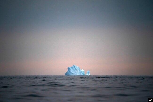 In this Aug. 15, 2019, file photo, a large Iceberg floats away as the sun sets near Kulusuk, Greenland. (AP Photo/Felipe Dana, File)