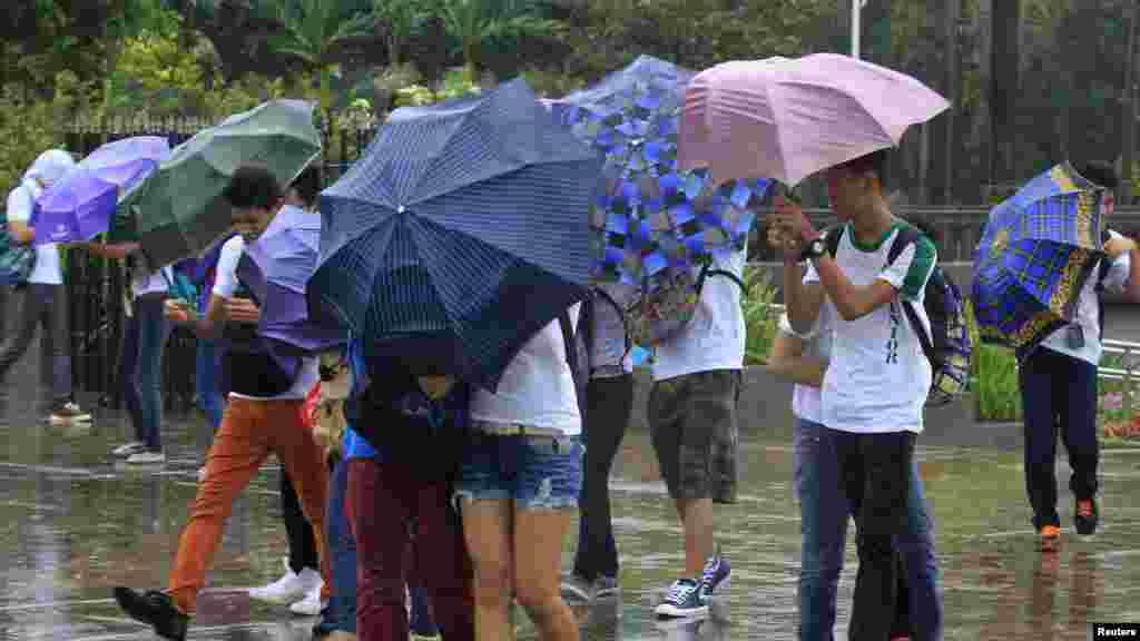 Participants for "Walk for Peace" use umbrellas in the rain brought on by Typhoon Kalmaegi, also called Luis, at Luneta park in Manila, Philippines, Sept. 14, 2014. 