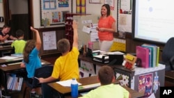 FILE - In this Sept. 18, 2013 file photo, Shelly Ellis teaches fourth-grade students in a newly air conditioned classroom at Bement Elementary School in Bement, Ill. AP Photo/David Mercer, File)