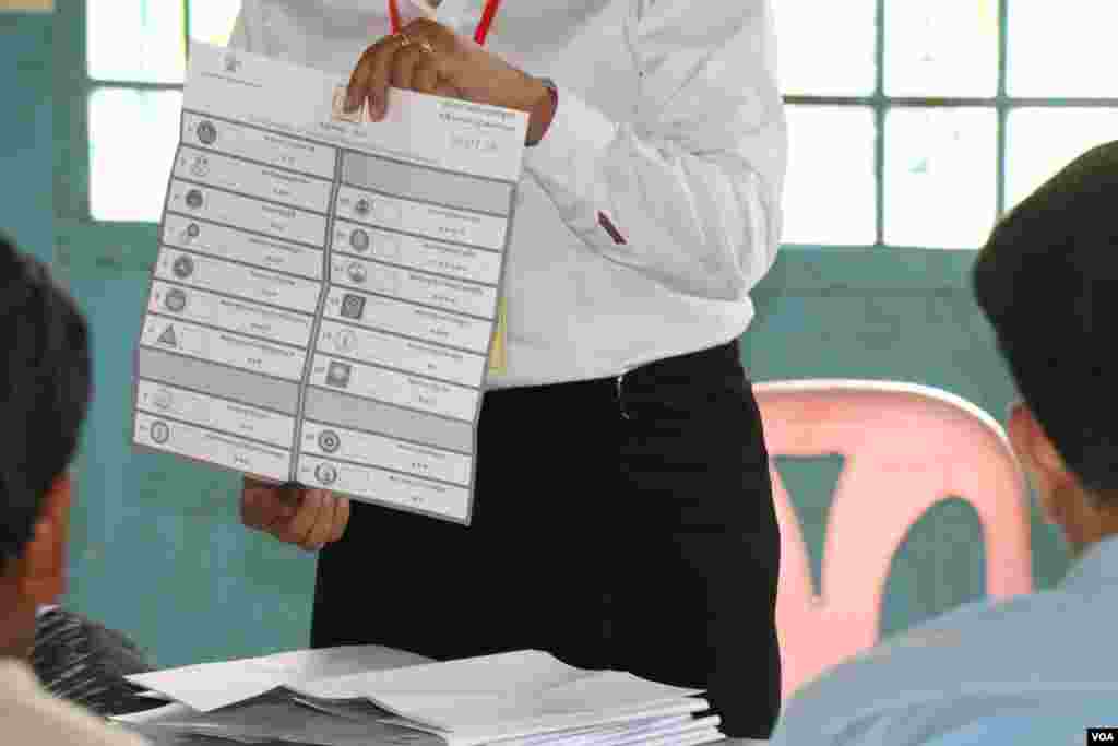 An unidentified election officer shows another spoiled ballot at a polling station in Sarikakeo commune, Lavea Am district, Kandal province, Cambodia, Sunday, July 29, 2018. (Sun Narin/VOA Khmer)