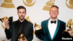 Hip hop artists Macklemore (R) and Ryan Lewis pose backstage with their awards for Best New Artist, Best Rap Performance for "Thrift Shop", Best Rap Song for "Thrift Shop" and Best Rap Album for "The Heist", Jan. 26, 2014.