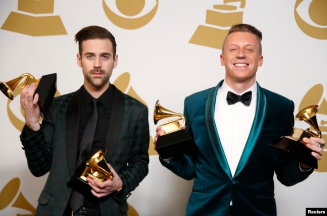 FILE - Hip hop artists Macklemore (R) and Ryan Lewis pose backstage with their awards for Best New Artist, Best Rap Performance for "Thrift Shop", Best Rap Song for "Thrift Shop" and Best Rap Album for "The Heist", Jan. 26, 2014.