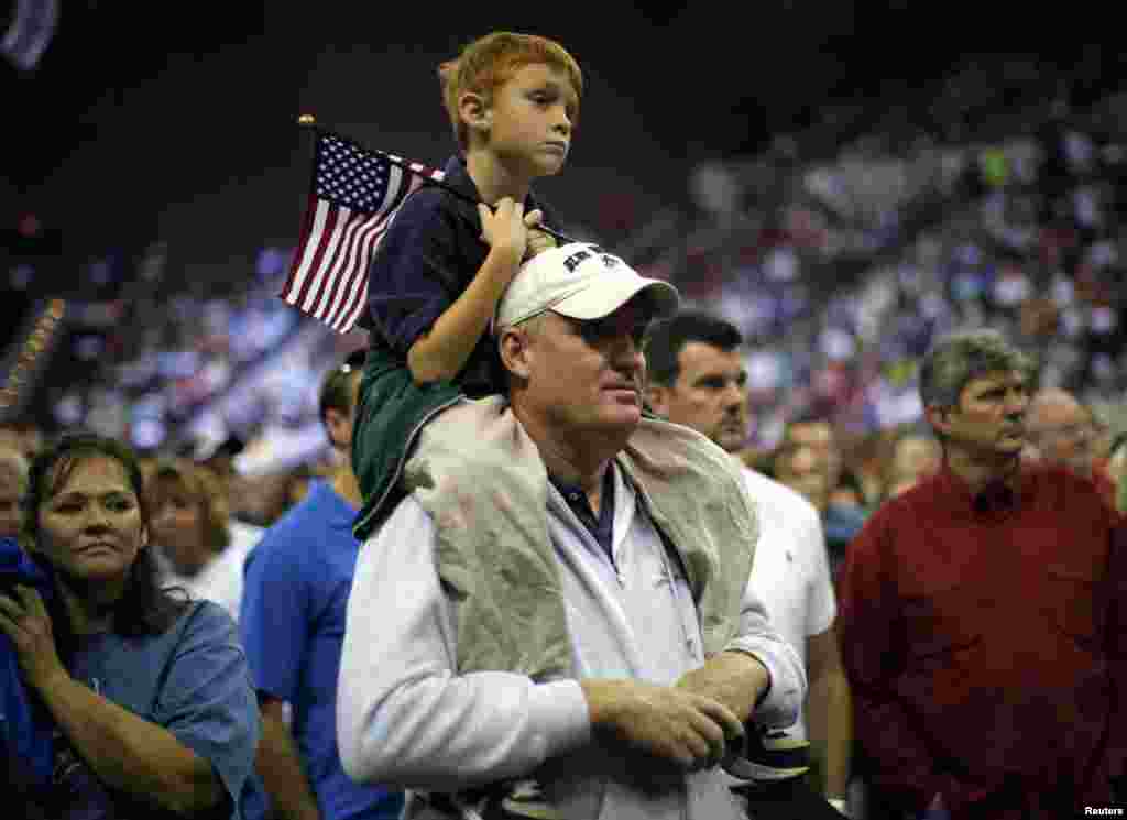 Audience members watch a biographical video about Republican presidential nominee Mitt Romney at a campaign rally in Pensacola, Florida, October 27, 2012.