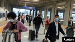 Travellers arrive at a train station ahead of China's upcoming Golden Week holiday following the coronavirus disease (COVID-19) outbreak, in Beijing, China September 29, 2021. 
