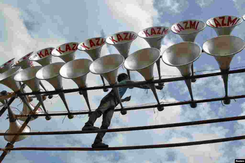 A worker installs loudspeakers at the venue of a rally organized by India&#39;s Samajwadi Party at a parade ground in the northern Indian city of Allahabad.