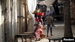FILE - Women walk through a market deserted following protests in Bujumbura, April 29, 2015. 