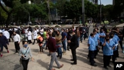 Nhân viên đứng ngoài các tòa nhà tại Mexico City sau trận động đất mạnh 7,4 độ Richter làm rung chuyển duyên hải miền Nam Mexico hôm 23/6.