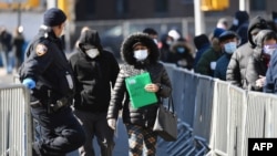 Ljudi odlaze iz bolnice u Queens u New Yorku pošto su testirani na korona virus.