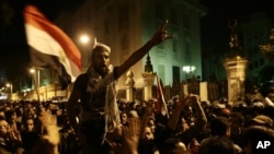 Egyptian protesters chant anti-Muslim Brotherhood and Egyptian President Mohammed Morsi slogans outside the presidential palace after they broke a barbed wire barricade keeping them from getting closer to the presidential palace, in Cairo, Dec. 7, 2012.