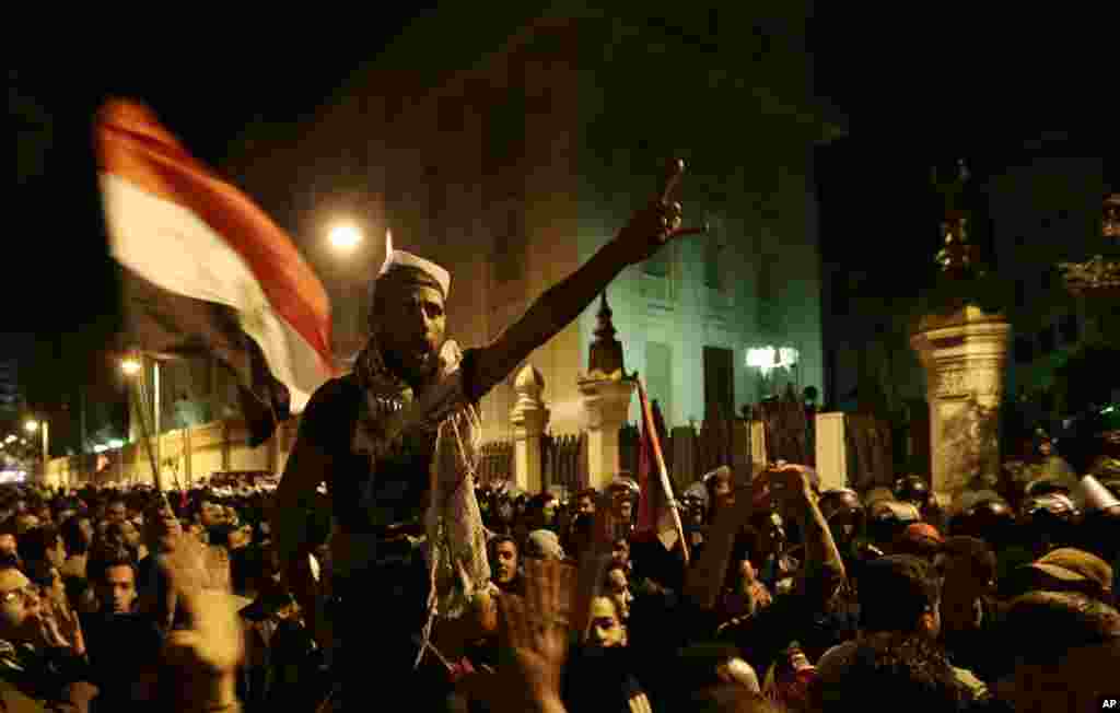 Egyptian protesters chant anti Muslim Brotherhood and Egyptian President Mohammed Mosri slogans outside the presidential palace after they broke a barbed wire barricade keeping them from getting closer to the presidential palace, in Cairo, Egypt, Friday, 
