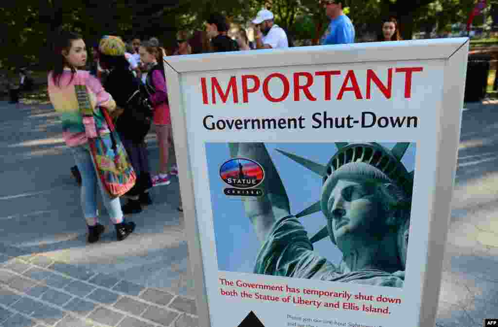 Tourists walk by a sign announcing that the Statue of Liberty is closed due to a U.S. government shutdown in New York. Government institutions and national parks were closed and thousands of employees were furloughed after Congress was unable to agree on a federal budget and shut down the goverment for the first time in 17 years.