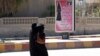 Veiled women walk past a billboard that carries a verse from Koran urging women to wear a hijab in the northern province of Raqqa, March 31, 2014. 