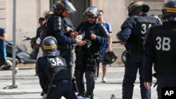 Un homme blessé dans des affrontements entre supporters est assisté par des policiers dans le centre de Marseille, France, 11 juin 2016. (AP Photo / Darko Bandic)