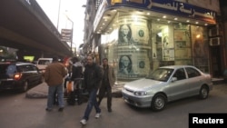 People walk past a foreign currency exchange center in Cairo (file photo).