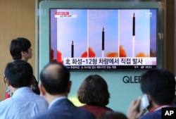 FILE - People watch a TV screen showing a local news program reporting about North Korea's missile launch, at the Seoul Railway Station in Seoul, South Korea, Sept. 16, 2017.