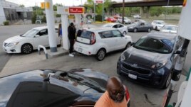 A person fills their car with gas as people queue at a Shell gas station, after a cyberattack crippled the biggest fuel pipeline in the country, run by Colonial Pipeline, in Washington, D.C., U.S., May 15, 2021. REUTERS/Andrew Kelly