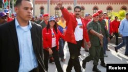 Venezuela's President Nicolas Maduro (C) gestures to supporters as he arrives for a ceremony commemorating the 22nd anniversary of late Venezuelan President Hugo Chavez's attempted coup d'etat in Caracas, Feb. 4, 2014.