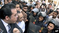 Egyptian opposition politician Ayman Nour (L) argues with anti-riot policemen blocking the road in front of his party headquarters, as dozens of protesters chant "freedom" and call for amending the constitution to allow fairer presidential elections, Cair