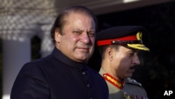 Newly elected Prime Minister of Pakistan Nawaz Sharif (L) arrives at the Prime Minister''s house to review guards of honor in Islamabad, June 5, 2013. 