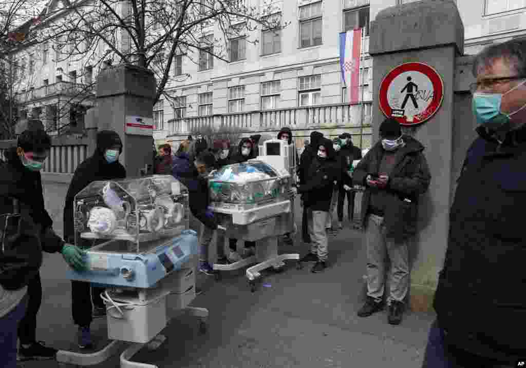 People carry incubators for newborn babies as the hospital is evacuated after an earthquake in Zagreb, Croatia.