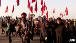 Des shiites musulmans marchent avec des drapeaux de leur mouvement lors d'un défilé de commémoration dans le village de Dakasoye, dans le nord du Nigeria, 27 novembre 2015.