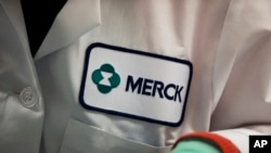 FILE - A Merck logo is placed on scientist's lab coat in West Point, Pennsylvania, Feb. 28, 2013. 