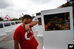 Savas Altay weeps as he visits an outdoor exhibition featuring photographs of July 15, 2016, coup attempt, in Istanbul, July 14, 2017. Turkey commemorates the anniversary with events honoring about 250 people who were killed while trying to oppose coup-pl