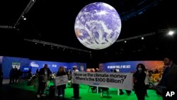 FILE - Protesters hold a sign inside the venue at the COP26 U.N. Climate Summit in Glasgow, Scotland, Nov. 5, 2021.