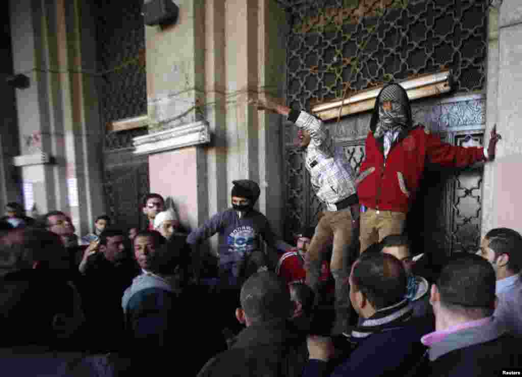 Protesters block the gate of a government building near Tahrir Square in Cairo December 11.