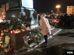 A woman approaches a memorial in Pushkin Square near the Kremlin, March 27, 2018, to those who died in a massive shopping mall blaze March 25 in the Siberian city of Kemerovo. A few hundred people were present at the vigil, though earlier there were a couple thousand at the site. (J. Dettmer/VOA)