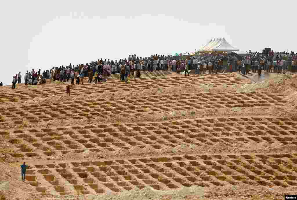 Grave holes are prepared as family members and friends attend the funeral of victims of a suicide bombing at a wedding celebration in the southern Turkish city of Gaziantep.