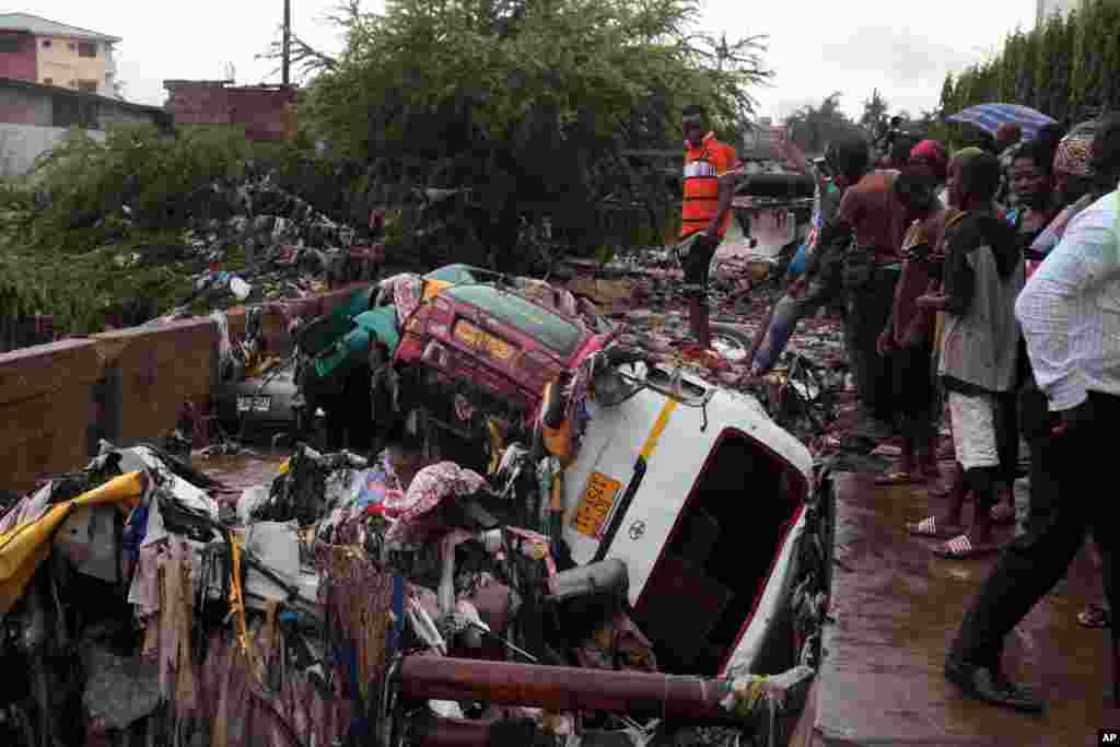 Mobil-mobil yang hanyut akibat hujan deras bertumpuk di dekat pom bensin di Accra, Ghana. Banjir di ibukota Ghana menyebabkan bahan bakar mengalir ke lokasi kebakaran dan menyebabkan ledakan hebat di pom bensi yang menewaskan setidaknya 100 orang, menurut pihak berwenang.