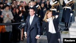 Ansyen Premye Minis Manuel Valls ak madanm li pandan yo tap kite yon seremoni d'adieu ofisyèl nan vil Pari nan jounen madi 6 desanm 2016 la.