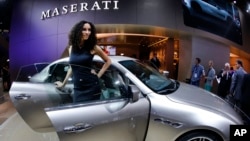 A hostess stands next to a Maserati Quattroporte during the first press day of the 65th Frankfurt Auto Show in Frankfurt, Germany, Sept. 10, 2013.